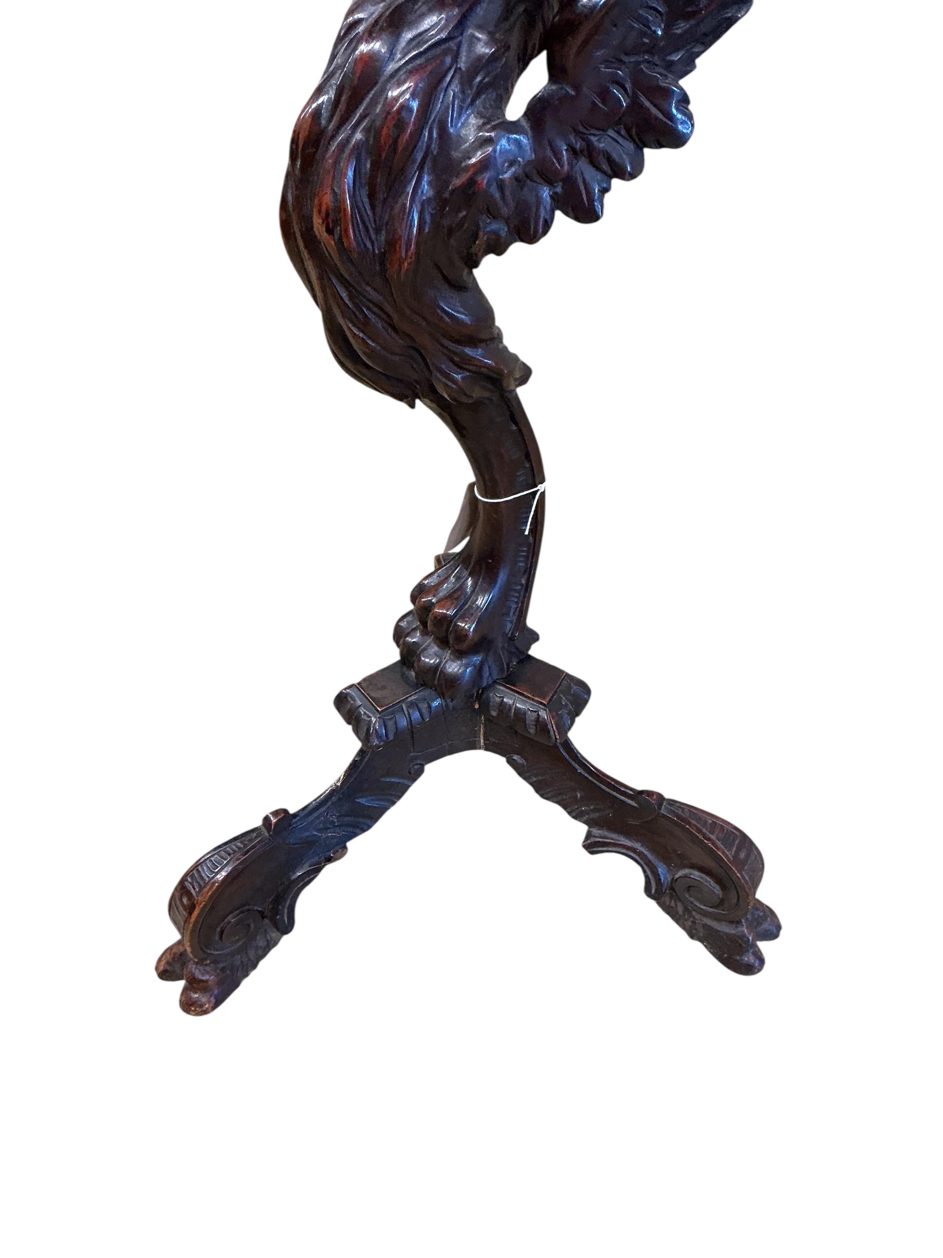 A 19th century Italian carved walnut griffin torchere, height 92cm